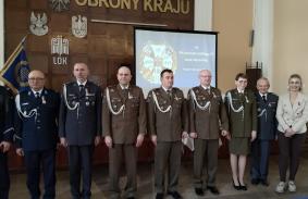 od lewej insp. Bogdan Ginalski Ekspert WPA, płk Radosław Śniegóła Z-ca Dowódcy 31. Bazy Lotnictwa Taktycznego, ppłk Mirosław Szychowski Z-ca Dowódcy 12. Wlkp. Brygady Obrony Terytorialnej, ppłk Krzysztof Słowik Szef Sztabu Brygady, mjr Damian Wolsztyniak Szef Sekcji Szkolenia Brygady, ppor. Katarzyna Antkowiak Oficer Sekcji Komunikacji Społecznej Brygady, płk Janusz Chwiejczak Prezes LOK, Izabela Bagrowska Sekretarz WZW LOK Poznań. 